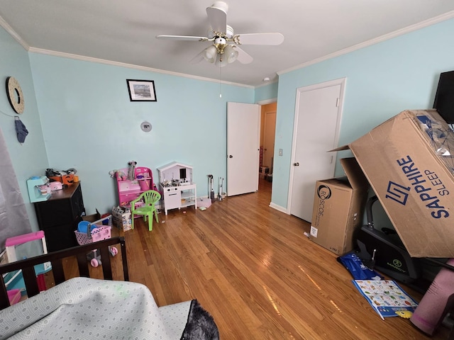 bedroom with crown molding, wood finished floors, and ceiling fan