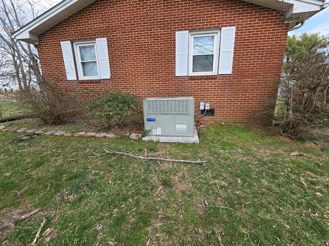 details featuring central AC unit and brick siding