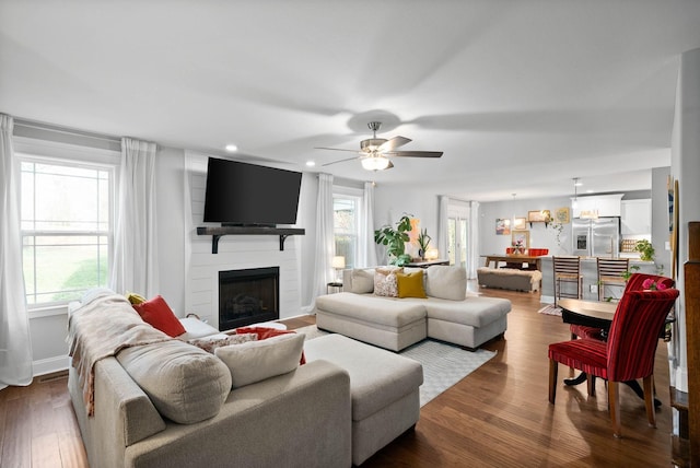 living room featuring recessed lighting, dark wood-type flooring, ceiling fan, and a fireplace