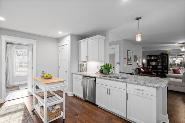 kitchen with open floor plan, dishwasher, a peninsula, white cabinetry, and a sink