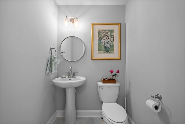 bathroom with tile patterned floors, toilet, and baseboards