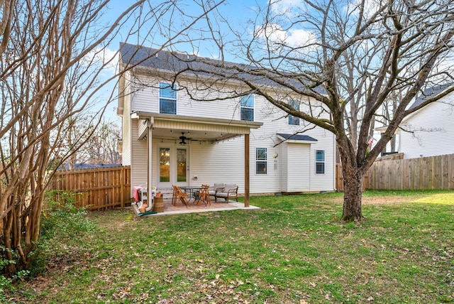 rear view of property with a patio, a lawn, a fenced backyard, and a ceiling fan