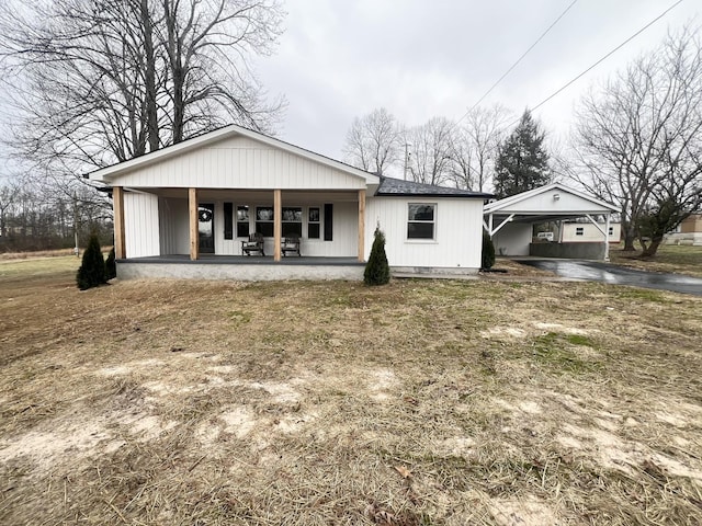 view of front of property featuring an attached carport, a porch, and driveway