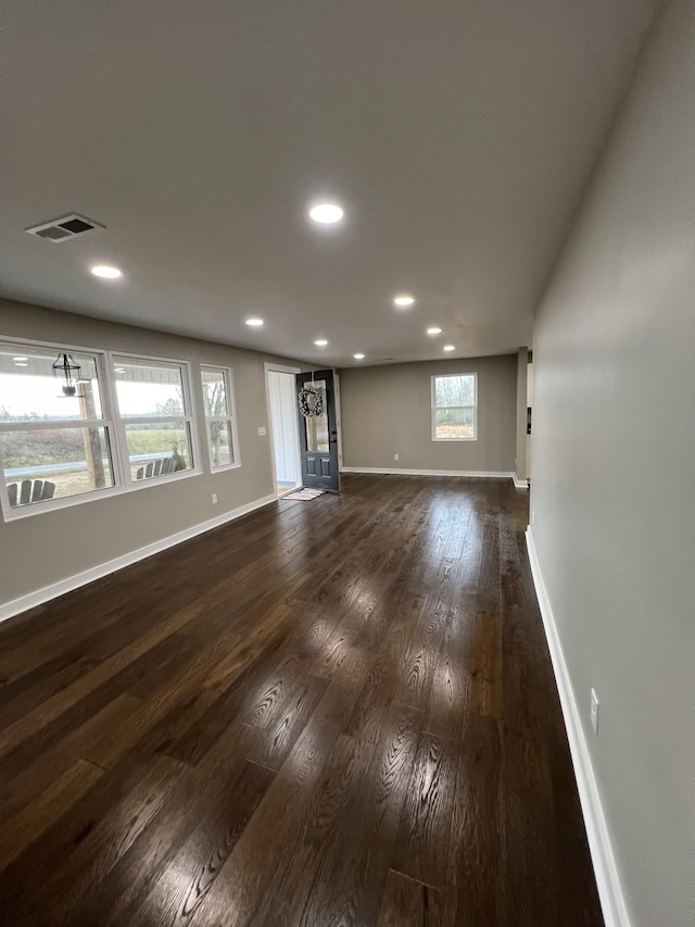 unfurnished living room featuring dark wood-style floors, visible vents, recessed lighting, and baseboards