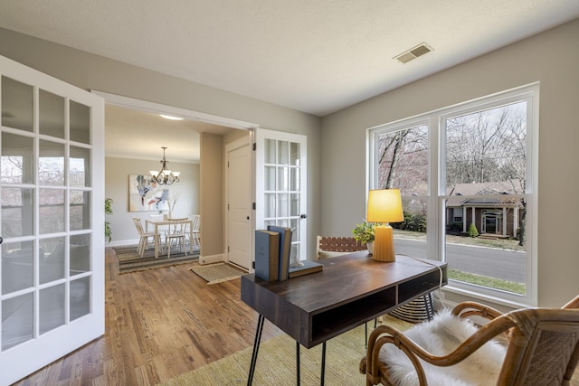 office with visible vents, baseboards, wood finished floors, and a chandelier