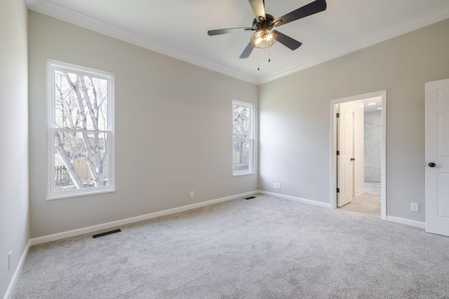 unfurnished bedroom with crown molding, multiple windows, light colored carpet, and visible vents