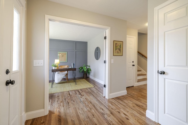 entrance foyer featuring a wealth of natural light, light wood-type flooring, and baseboards