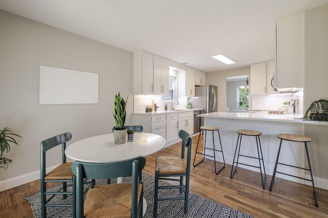 dining area featuring light wood-type flooring and baseboards