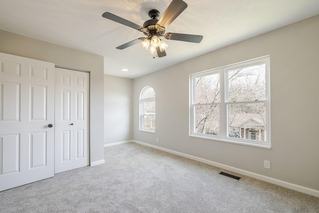 unfurnished bedroom featuring a closet, visible vents, carpet flooring, and baseboards