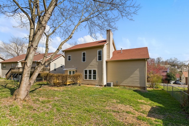 back of property with fence, central AC unit, a lawn, a chimney, and a deck