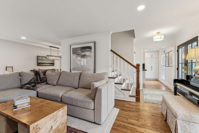 living area with ornamental molding, wood finished floors, recessed lighting, baseboards, and stairs