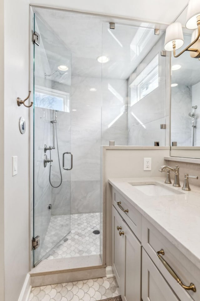 bathroom featuring a marble finish shower and vanity