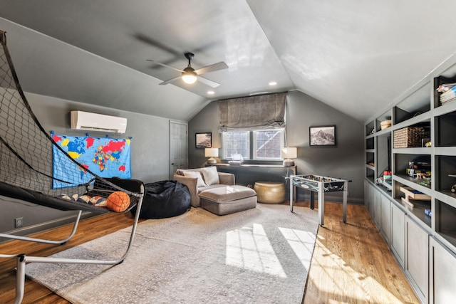 recreation room featuring built in features, wood finished floors, a wall unit AC, lofted ceiling, and ceiling fan