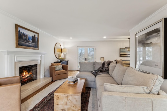 living area with recessed lighting, a fireplace, wood finished floors, and ornamental molding