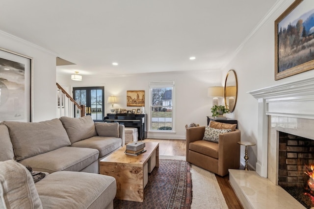 living room featuring crown molding, stairway, recessed lighting, a fireplace, and wood finished floors