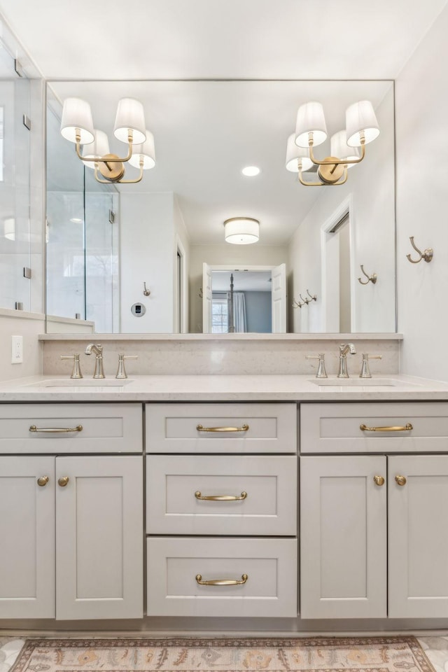 full bath with a sink, double vanity, and a chandelier