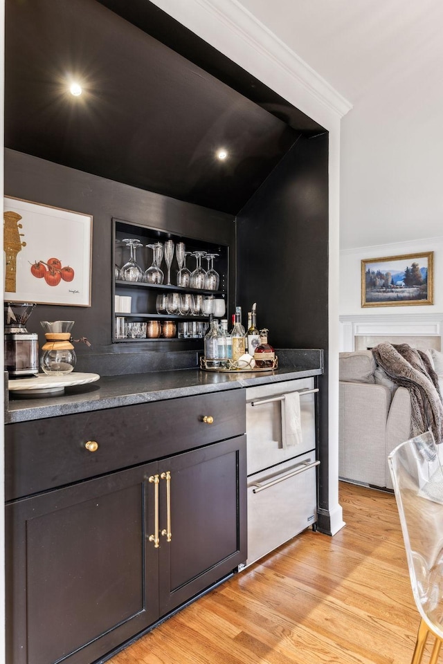 bar featuring a dry bar, light wood-type flooring, and crown molding