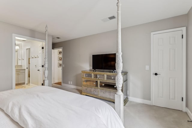 bedroom with light colored carpet, visible vents, ensuite bathroom, and baseboards