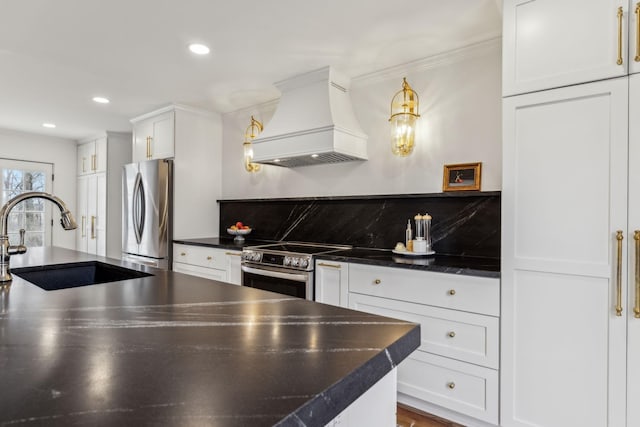 kitchen with custom exhaust hood, a sink, white cabinets, appliances with stainless steel finishes, and dark countertops