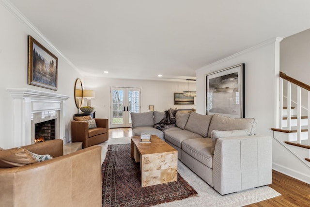 living area featuring a high end fireplace, crown molding, stairs, recessed lighting, and wood finished floors