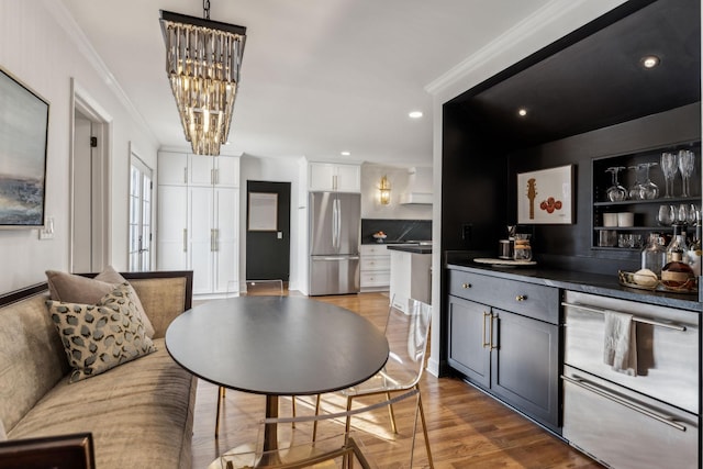 dining area featuring recessed lighting, wood finished floors, a chandelier, and ornamental molding