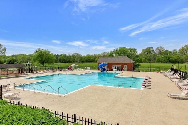 pool featuring an outbuilding, fence, and a patio area