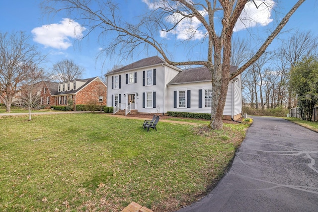 colonial home with aphalt driveway and a front lawn