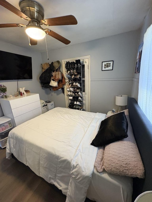 bedroom featuring a ceiling fan and dark wood-style flooring