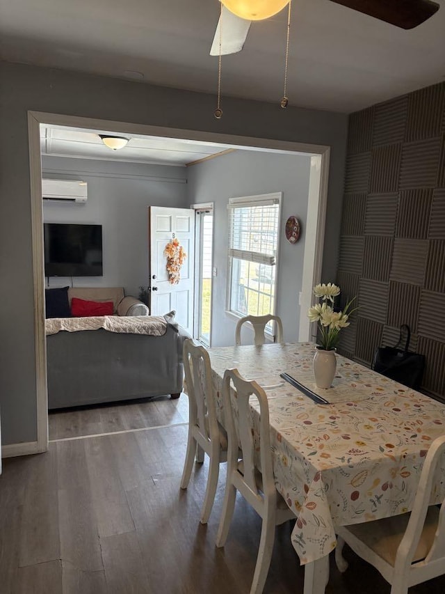 dining space with an AC wall unit and wood finished floors