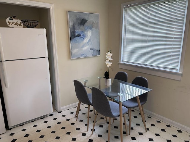 dining area with light floors, baseboards, and a healthy amount of sunlight