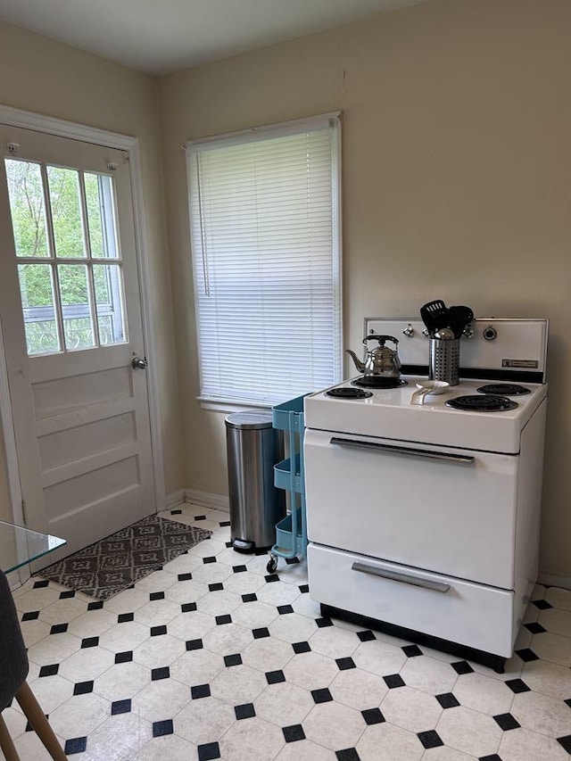 interior space with baseboards, light floors, and electric stove