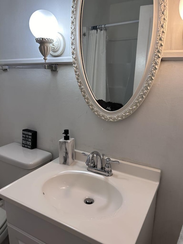 bathroom featuring a shower with curtain, toilet, and vanity