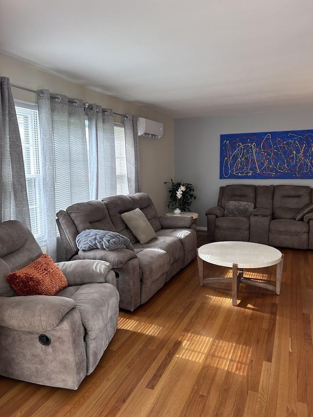 living room with light wood-style flooring, a healthy amount of sunlight, and a wall mounted air conditioner