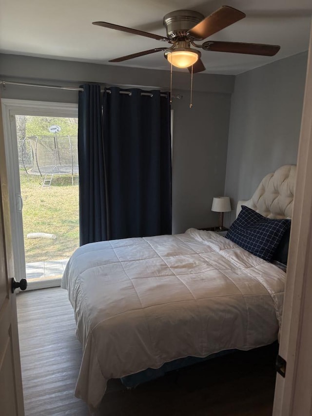 bedroom featuring wood finished floors, access to outside, and a ceiling fan