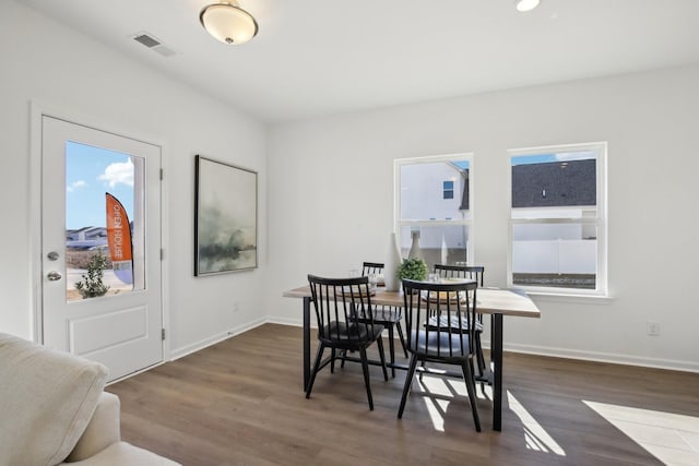 dining room featuring baseboards, wood finished floors, and visible vents