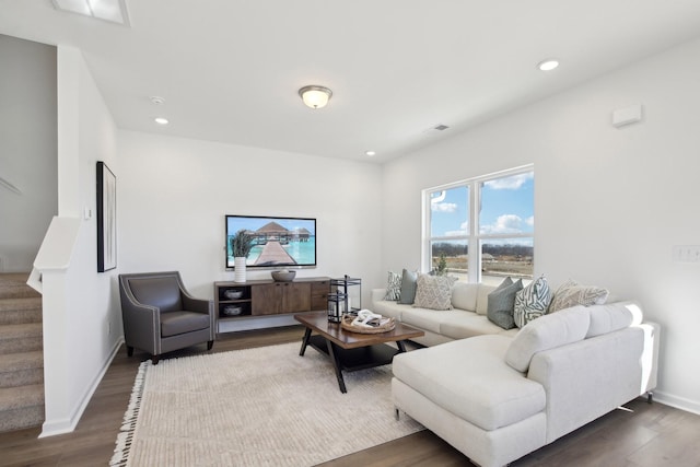 living room featuring stairs, baseboards, dark wood-style flooring, visible vents, and recessed lighting