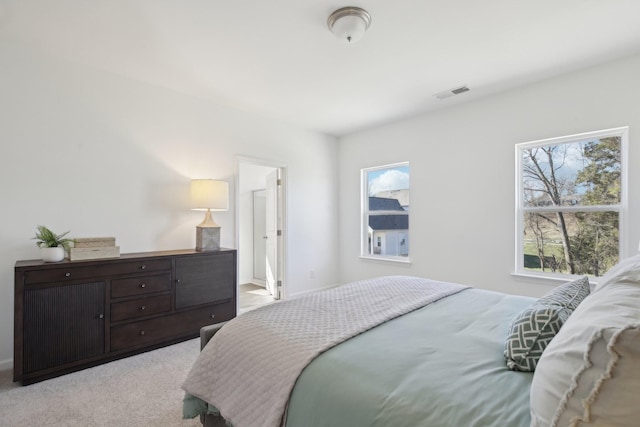 bedroom with visible vents and light carpet