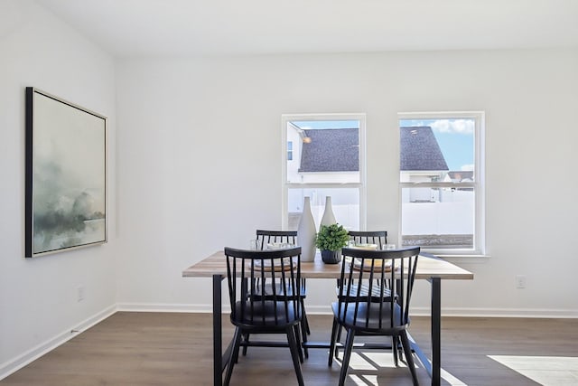 dining space with dark wood finished floors and baseboards