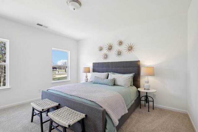 carpeted bedroom featuring baseboards and visible vents