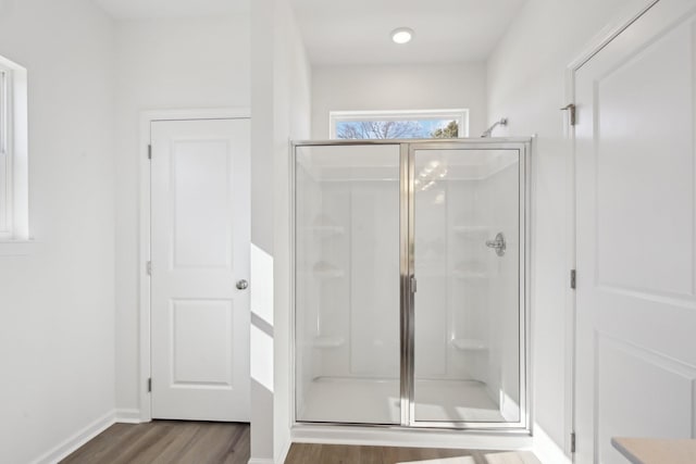 full bathroom with baseboards, wood finished floors, and a stall shower