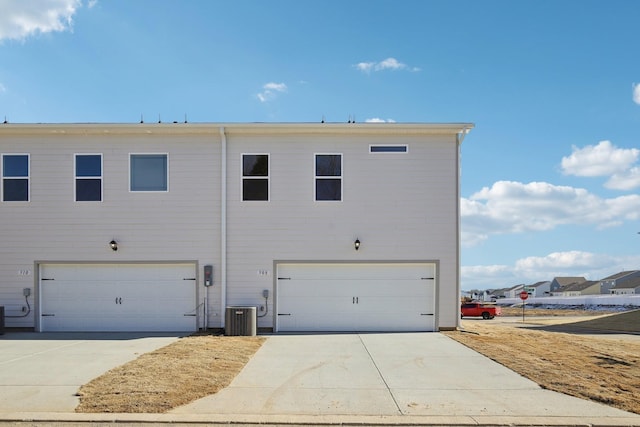 exterior space with concrete driveway, cooling unit, and a garage