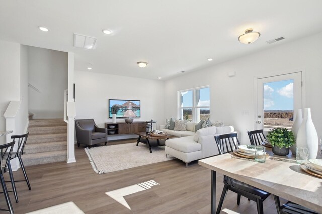 living area featuring recessed lighting, stairway, visible vents, and light wood finished floors