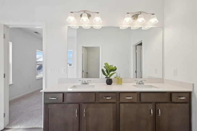 full bathroom with baseboards, visible vents, a sink, and double vanity