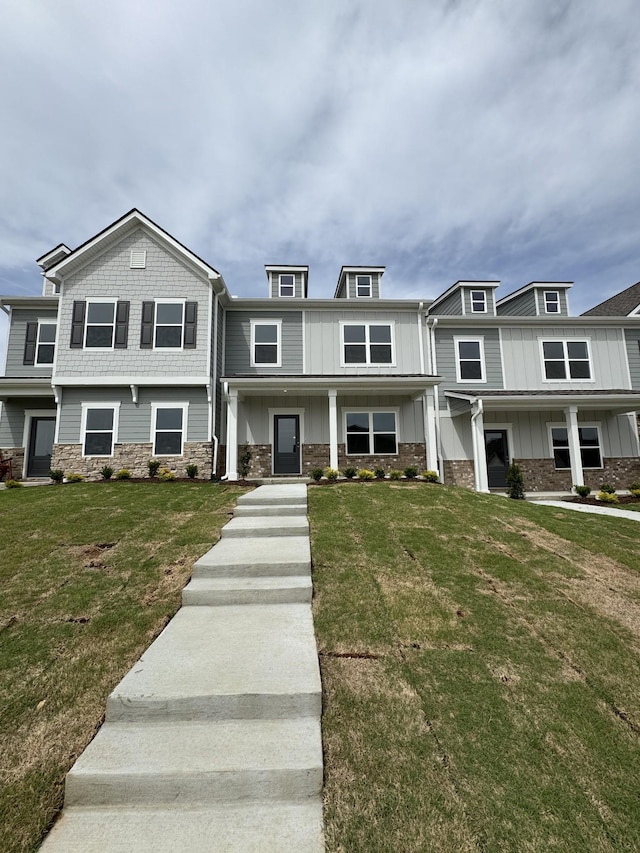 view of front facade featuring stone siding and a front lawn