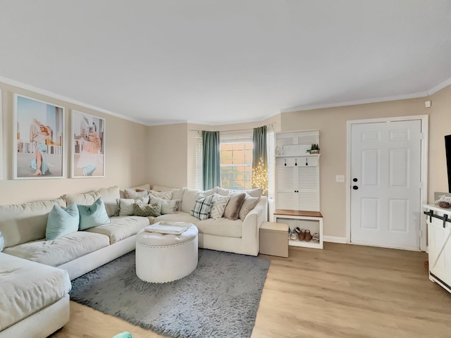 living room with crown molding, light wood-style flooring, and baseboards