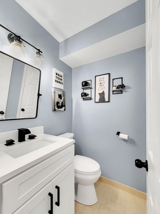 bathroom with vanity, toilet, and baseboards