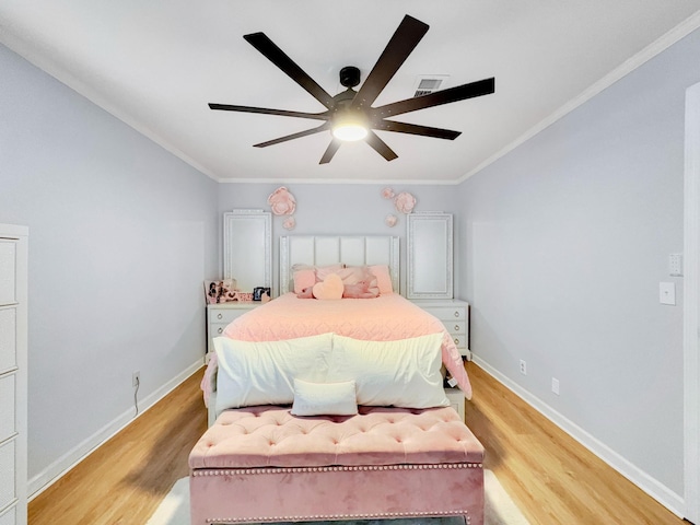 bedroom with visible vents, baseboards, light wood-style flooring, and ornamental molding