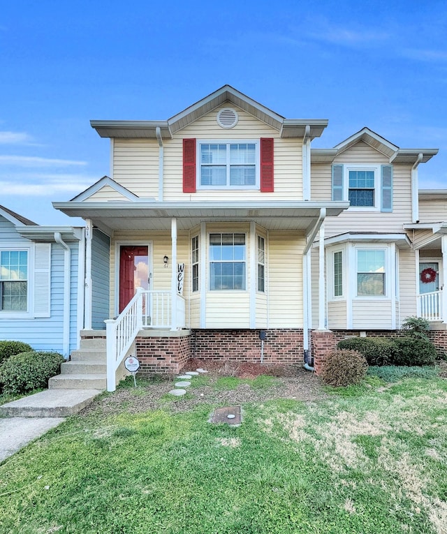 townhome / multi-family property featuring a porch and a front yard