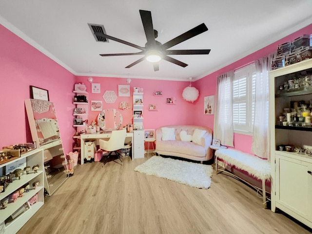 living area featuring visible vents, ornamental molding, ceiling fan, and wood finished floors