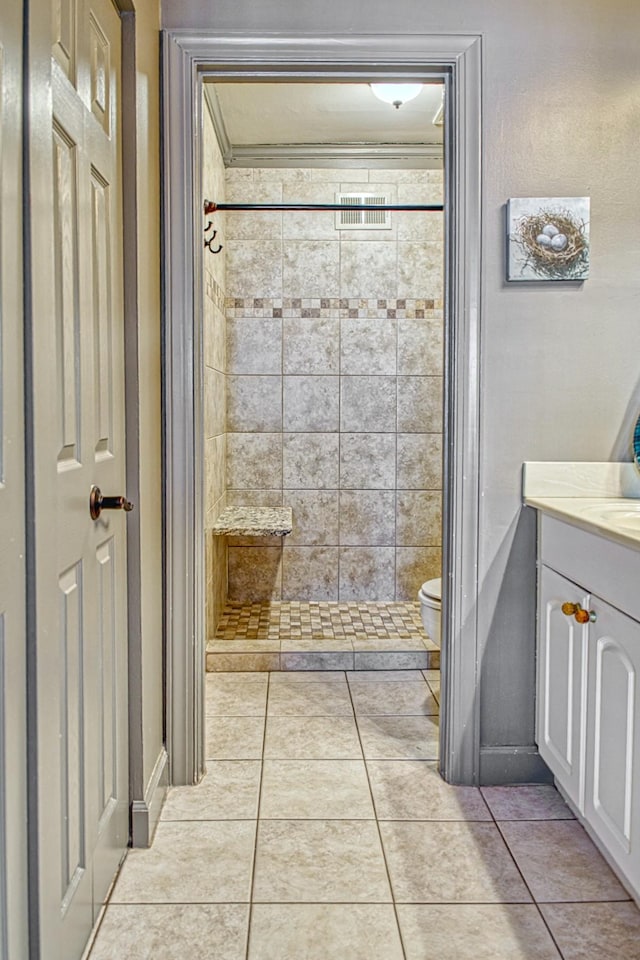 bathroom with toilet, a stall shower, vanity, and tile patterned flooring